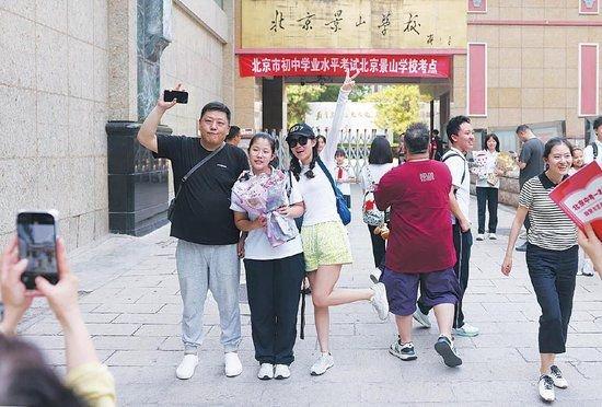 6月25日,北京景山学校考点,家长和考生在考点外合影留念。 新京报记者 李木易 摄