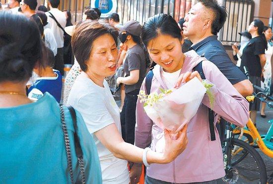 6月8日，广渠门中学考点，家长为走出考场的孩子送上鲜花。