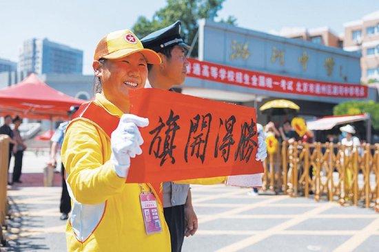 6月8日，潞河中学考点，文明引导员高举手写祝福语。